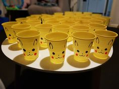 many yellow cups with faces painted on them