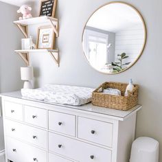 a baby's room with a dresser and mirror