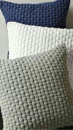 three pillows with different patterns on them, one is blue and the other is white