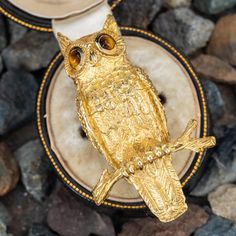 an owl figurine sitting on top of some rocks