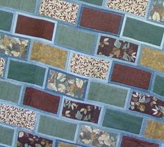 a close up view of a wall made out of patchwork material with leaves and flowers on it