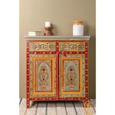 an ornate painted cabinet with candles on top