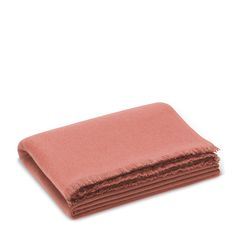 the pink blanket is folded on top of each other