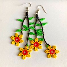 the beaded earrings are decorated with yellow and red flowers on black beads, along with green leaves