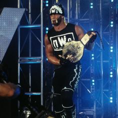 a man holding a wrestling belt on top of a stage