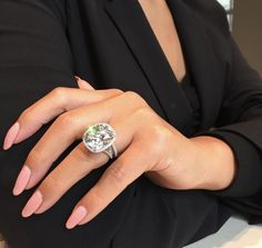 a woman's hand wearing a ring with an oval shaped diamond on the center