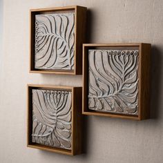 three wooden framed artwork pieces on a wall