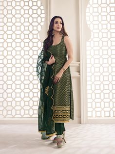 This great winter ensemble from Malaika Arora is perfect for your next special occasion. It includes a bottle green kurta set crafted from silk blend brocade, cotton and organza. Featuring Zari woven designs, a U-neck and calf length trousers, this set is sure to make a statement. It is dry clean only and designed specifically by the Bollywood Diva herself. TOP: Silk Blend(Brocade), TOP INNER: Cotton, BOTTOM: Cotton, DUPATTA: Organza, Dry Clean Kurti Neck Designs Sleeveless, Sleeveless Long Kurti, Bottle Green Suits Women Indian, Green Kurta Set Women, Brocade Kurta Designs, Green Kurti Outfit, Straight Suit Designs, Women Kurta Designs Style, Green Suit Design