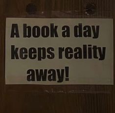 a book a day keeps reality away sticker on a wooden door that says, a book a day keeps reality away