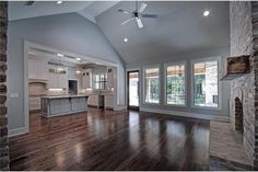 an empty living room with wood floors and windows