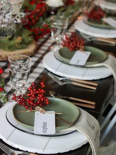 the table is set with plates and place settings for christmas dinner guests to eat at