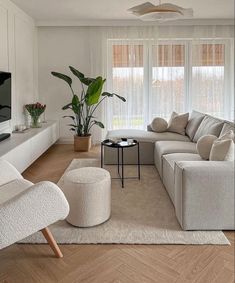 a living room filled with furniture and a flat screen tv on top of a wooden floor