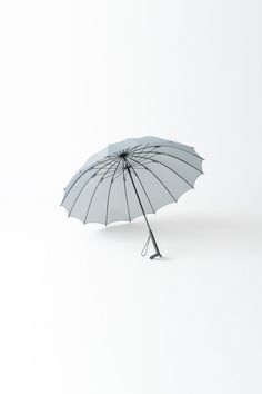 an open umbrella sitting on top of a white floor next to a black object in the air