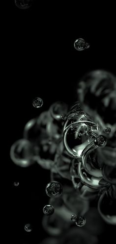 a black and white photo with bubbles in the air on a black background that appears to be floating