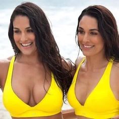 two beautiful women in yellow bikinis standing next to each other
