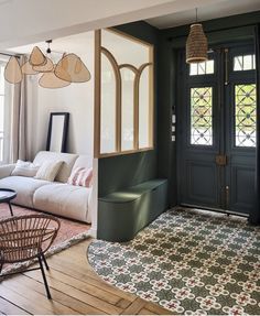 a living room filled with furniture next to a door and window covered in glass panels