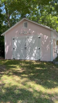 a pink shed with two doors and windows