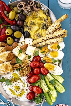 a platter filled with different types of food on top of a blue wooden table