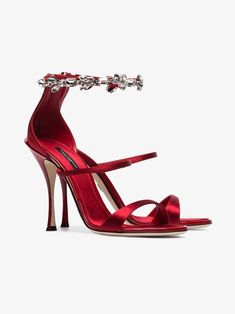 a red high heeled sandal with an ankle chain