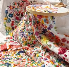 a close up of a flowered bedspread with a wooden tray on it