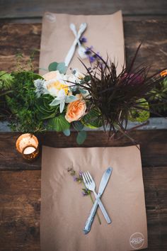 the table is set with flowers and silverware