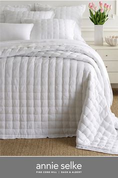 an image of a bed with white comforter and pillows