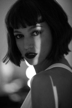 a black and white photo of a woman with dark lipstick