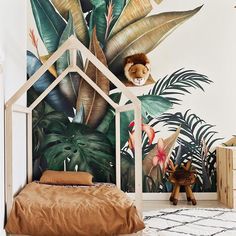 a child's bedroom decorated with tropical wallpaper and jungle themed mural on the walls