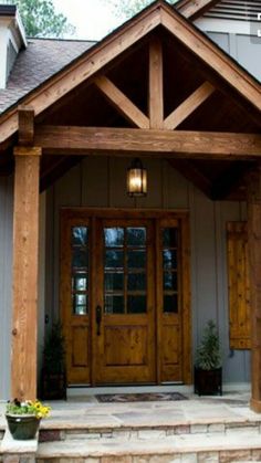 the front entrance to a house with wooden doors