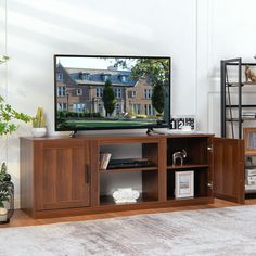 a flat screen tv sitting on top of a wooden entertainment center in a living room