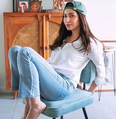 a woman sitting on top of a blue chair