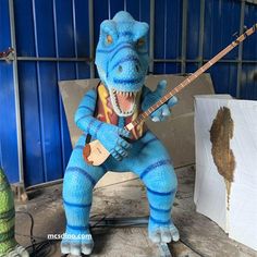 a blue dinosaur with a guitar in his hands