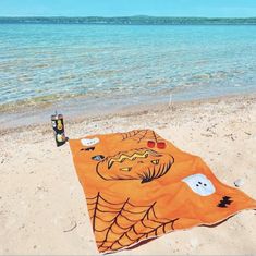an orange towel on the beach with halloween decorations