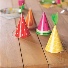 paper party hats sitting on top of a wooden table