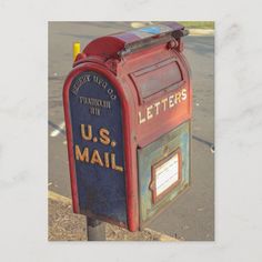 a red mailbox with the letter u s mail on it's side next to a street