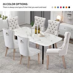 a dining table with white chairs and a bottle of wine on the table next to it