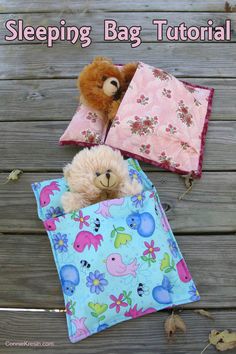 a teddy bear in a sleeping bag with two pillows on the ground next to it