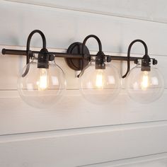 three light fixtures mounted on the side of a wall