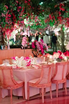 the tables are set up with pink and white flowers on them for an elegant dinner