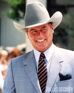 a man wearing a gray suit and hat