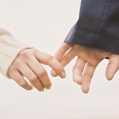 two hands reaching out towards each other with one hand holding the other's finger