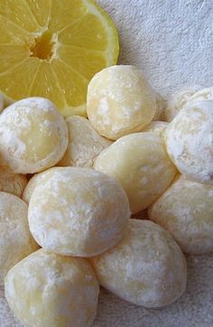 a pile of powdered doughnuts next to a lemon slice
