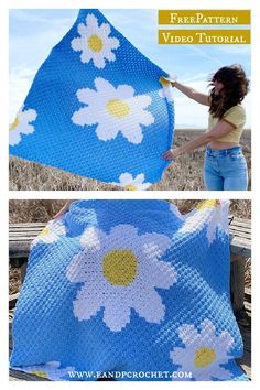 a woman holding up a blue crocheted blanket with white daisies on it