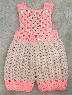 a crocheted baby outfit laying on top of a white rug