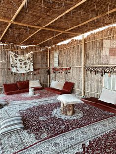 a living room with couches and rugs in the middle, that is made out of straw