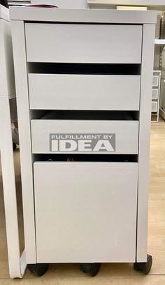 a white filing cabinet sitting on top of a hard wood floor