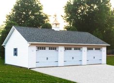 a white garage with three windows and two doors