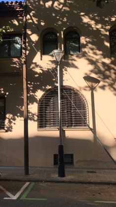 a street light sitting next to a tall building with three windows on it's side