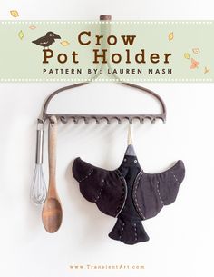 a pot holder with two birds hanging from it's hooks and a whisk on the hook