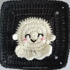 a crocheted square with a smiling sheep on it